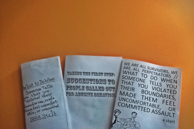Photo of three zines discussed in this blog post against an orange wall.